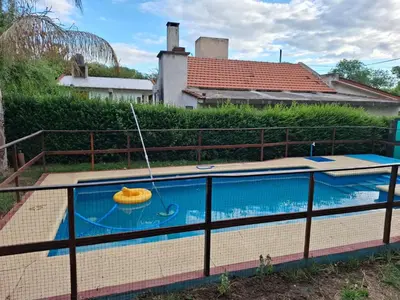 a swimming pool with a raft in a house at Orión VGB in Villa General Belgrano