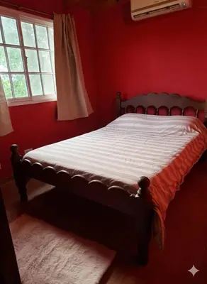 a red bedroom with a bed in a room with a window at Orión VGB in Villa General Belgrano