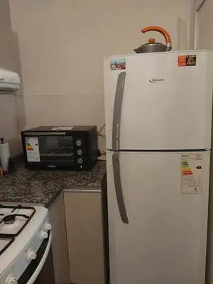 a white refrigerator in a kitchen next to a microwave at Puesta de Sol in Cordoba