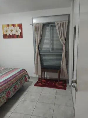 a bedroom with a window with a chair next to a bed at Puesta de Sol in Cordoba