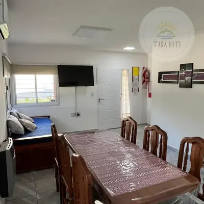a room with a table and chairs and a bed at Tara Inti in Merlo