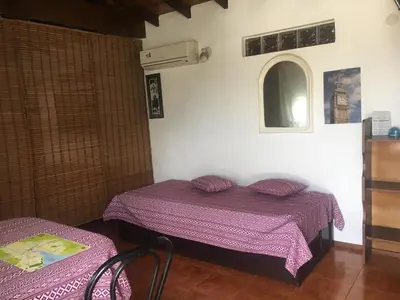 a bedroom with a bed with purple sheets and a window at Bienvenidos a la Casa de Graciela & Carlos in Villa Carlos Paz