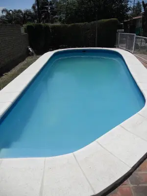 a large blue swimming pool in a yard at Bienvenidos a la Casa de Graciela & Carlos in Villa Carlos Paz