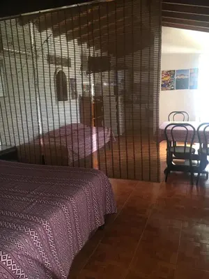 a bedroom with a bed and a table and chairs at Bienvenidos a la Casa de Graciela & Carlos in Villa Carlos Paz