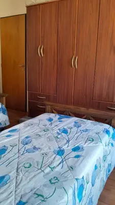a bedroom with a bed with blue flowers on it at Habitación doble SOLO PARA DAMAS in Villa General Belgrano