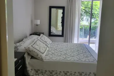 a bedroom with a bed with a mirror and a window at Amplio Departamento en Nueva Cordoba in Cordoba