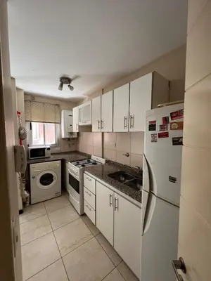 a kitchen with white appliances and white cabinets at Amplio Departamento en Nueva Cordoba in Cordoba