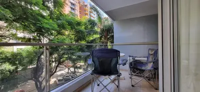 a balcony with two chairs and a table in front of a window at Amplio Departamento en Nueva Cordoba in Cordoba