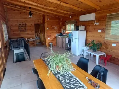 a dining room and kitchen in a log cabin at Las Piedras in Cuesta Blanca