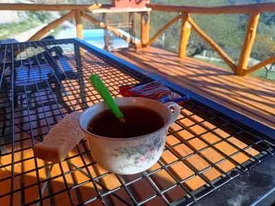 a cup of coffee sitting on a rack on a porch at Las Piedras in Cuesta Blanca