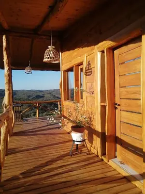 a porch of a wooden house with a potted plant at Las Piedras in Cuesta Blanca
