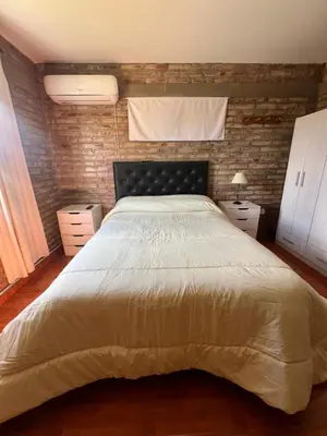 a bedroom with a large bed and a brick wall at El descanso in Villa del Dique