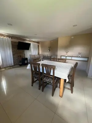 a dining room with a white table and chairs at El descanso in Villa del Dique