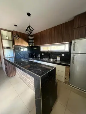 a kitchen with black counter tops and a refrigerator at El descanso in Villa del Dique