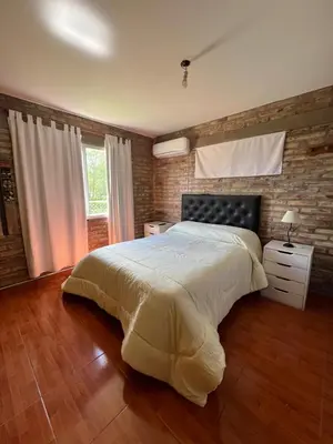 a bedroom with a large bed and a wooden floor at El descanso in Villa del Dique