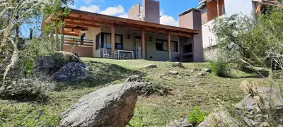 a house on top of a grassy hill in front at Mirador de baco in Santa Rosa de Calamuchita