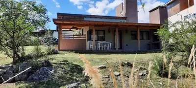 a house with a table and chairs in a yard at Mirador de baco in Santa Rosa de Calamuchita
