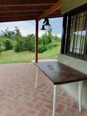 a wooden bench sitting on a brick patio at Mirador de baco in Santa Rosa de Calamuchita
