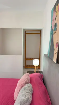 a bedroom with a bed with a pink blanket at Habitación con baño zona cucú 2 personas in Villa Carlos Paz