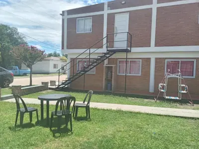 a table and chairs in front of a building with a fire escape at Bonita in Villa Cura Brochero