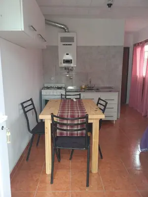 a kitchen with a wooden table and chairs in a room at Bonita in Villa Cura Brochero