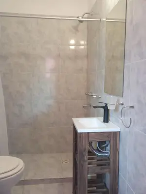 a bathroom with a sink and a toilet and a mirror at Bonita in Villa Cura Brochero
