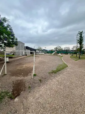 a dirt field with a fence in front of a building at Departamento para dos personas VILLA SOL in Cordoba