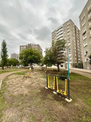 a park with a playground with benches and buildings at Departamento para dos personas VILLA SOL in Cordoba