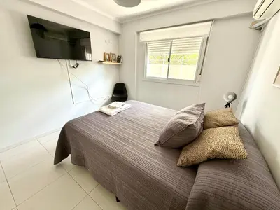 a bedroom with a bed with a tv on the wall at Departamento para dos personas VILLA SOL in Cordoba