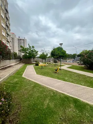 a park with benches on the grass next to a sidewalk at Departamento para dos personas VILLA SOL in Cordoba