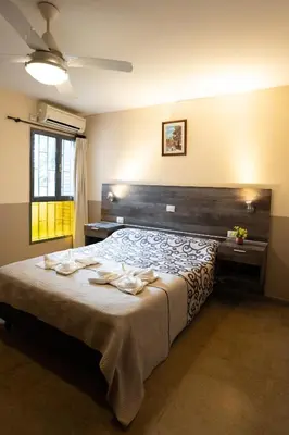 a bedroom with a bed with towels on it at Hosteria Cruz del Sur in Villa Carlos Paz