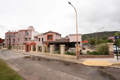 an empty street with a fence and some buildings at Hosteria Cruz del Sur in Villa Carlos Paz