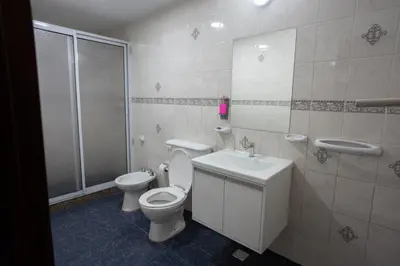 a bathroom with a toilet and a sink at Hosteria Cruz del Sur in Villa Carlos Paz