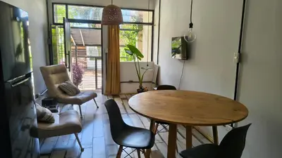 a living room with a wooden table and chairs at Espacio Inn zona Kempes in Cordoba