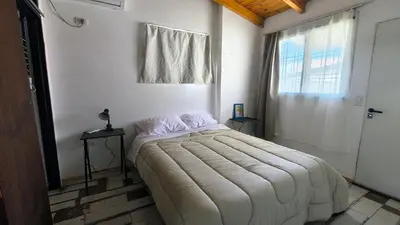 a bedroom with a large bed in a room with a window at Espacio Inn zona Kempes in Cordoba