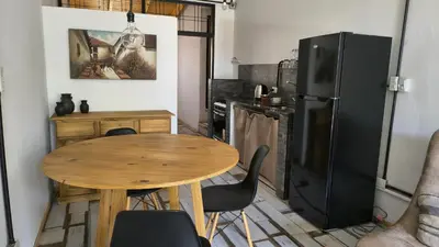 a kitchen with a wooden table and a black refrigerator at Espacio Inn zona Kempes in Cordoba