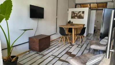 a living room with a table and a tv on the wall at Espacio Inn zona Kempes in Cordoba