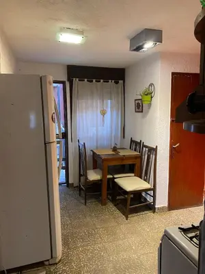 a kitchen with a table and chairs and a refrigerator at Alta Casa in Cordoba