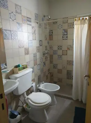 a bathroom with a toilet and a sink at Posta de Los Geranios in Villa Parque Siquiman