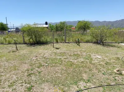 a field with a fence and trees in it at Posta de Los Geranios in Villa Parque Siquiman