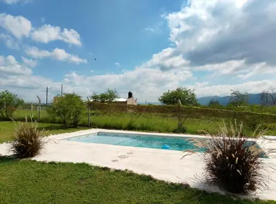 a swimming pool in the middle of a yard at Posta de Los Geranios in Villa Parque Siquiman