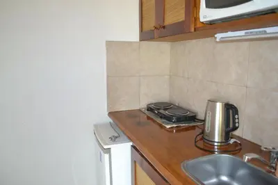a kitchen with a sink and a counter top at Rumi Huasi Cabañas in Mina Clavero