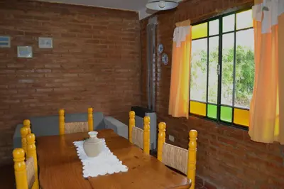 a wooden table with a vase on it in a room at Rumi Huasi Cabañas in Mina Clavero