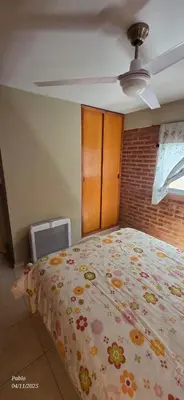 a bedroom with a bed with a floral bedspread at Cabañas Don Lelio 2 in Mina Clavero