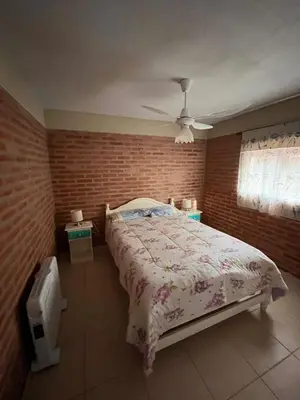 a bedroom with a bed and a brick wall at Cabañas Don Lelio 2 in Mina Clavero