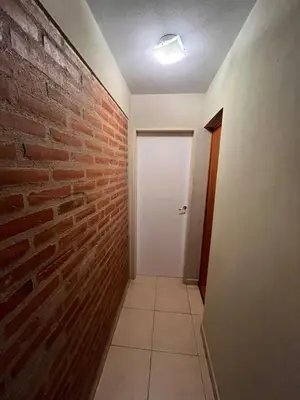 a hallway with a brick wall and a white door at Cabañas Don Lelio 2 in Mina Clavero
