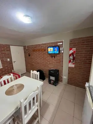 a living room with a white table and a fireplace at Cabañas Don Lelio 2 in Mina Clavero