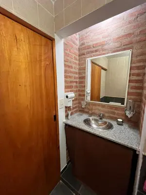 a bathroom with a sink and a wooden door at Cabañas Don Lelio 2 in Mina Clavero