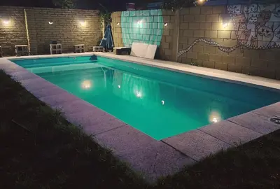 a swimming pool lit up at night with lights at Panorámica Sierras in Villa Carlos Paz
