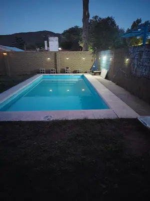 a swimming pool in a backyard at night at Panorámica Sierras in Villa Carlos Paz